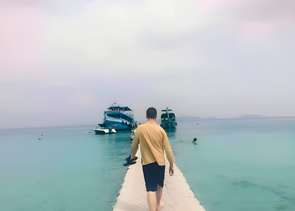 BFITS Thailand Teacher Chris Whearty walking toward docked boats