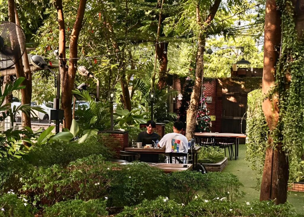 Two people dining in a lush, green outdoor garden surrounded by trees