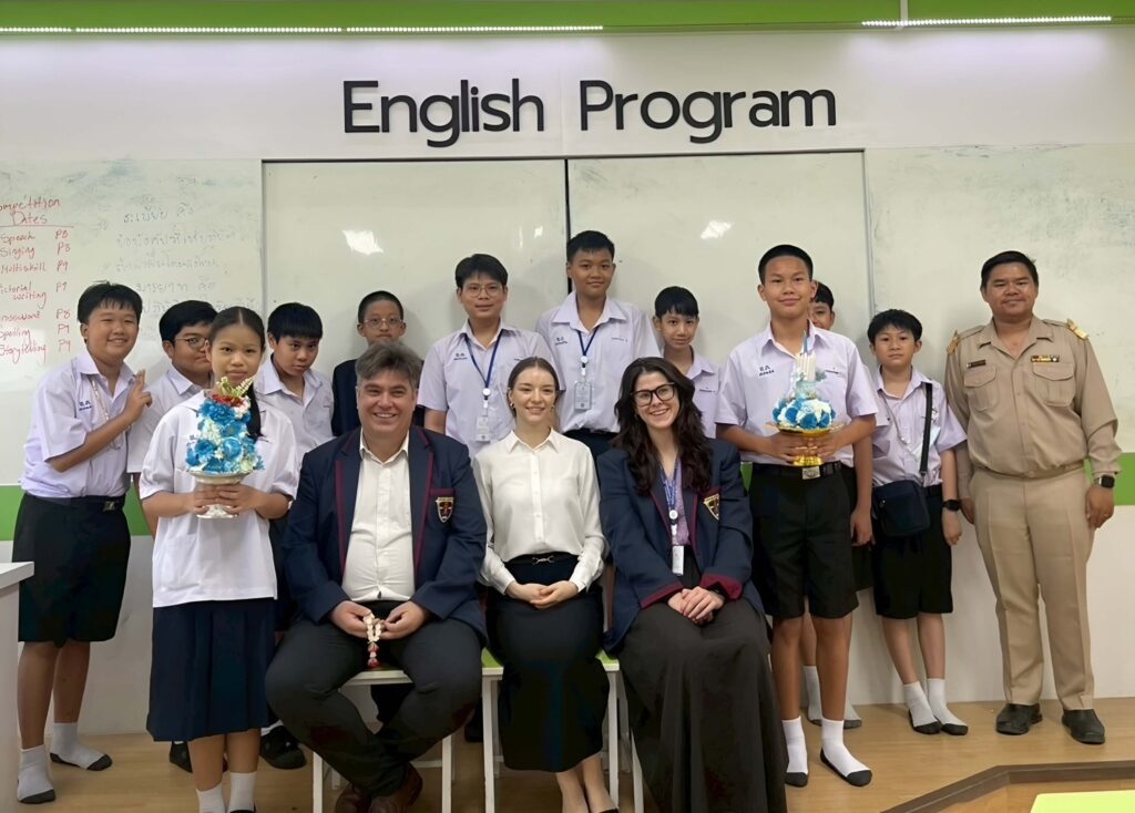 BFITS Teacher Paige Collins with colleagues and Thai students posing for a group photo in the BFITS English Program classroom at Watkhemapirataram (WKM) School